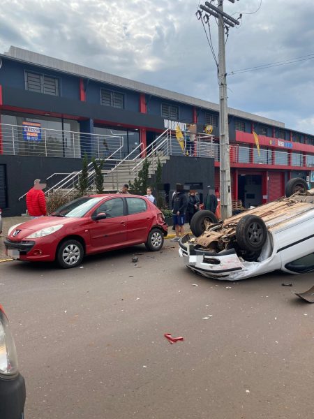 Carro capota após colidir contra veículo estacionado